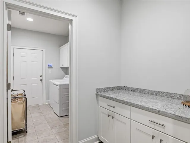 A well-appointed laundry area features convenient storage solutions and durable countertops.