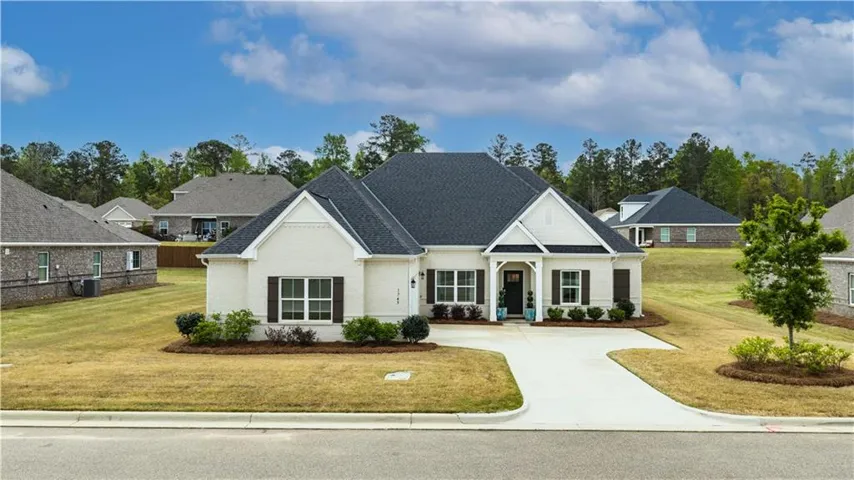 White brick home with dark shutters and an attached two-car garage welcomes you in a tranquil neighborhood.