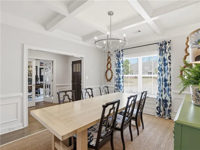 Elegant coffered ceilings and wainscoting adorn this inviting dining space, ready for memorable meals.