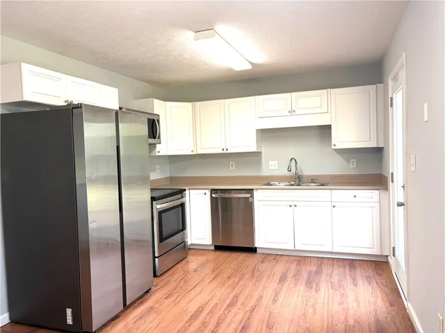 This functional kitchen showcases ample cabinetry, modern appliances, and durable flooring for daily living.