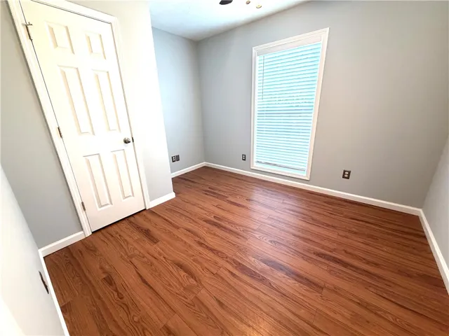 This naturally illuminated bedroom offers durable wood flooring and ample space for comfortable living.