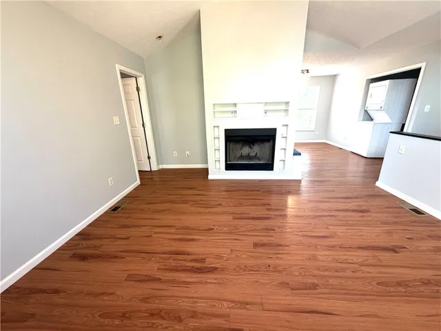 This generously proportioned living space features rich hardwood flooring and a stylish fireplace, ideal for relaxation.