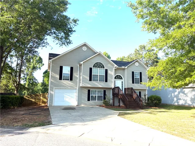A split-level residence with inviting porch steps and an integrated garage awaits.