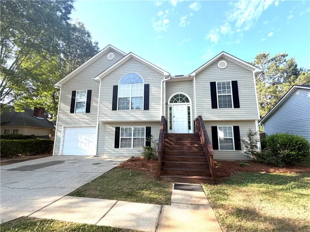 This residence showcases a split-level design with welcoming entry stairs and an attached garage.