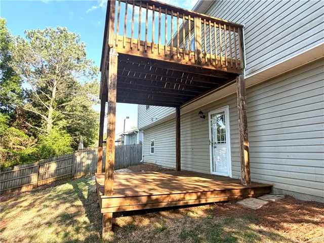Relax on this property's elevated deck, offering ample outdoor living space and serene backyard views.