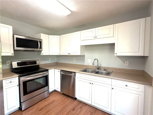 This kitchen showcases stainless steel appliances and ample white cabinetry for modern functionality.