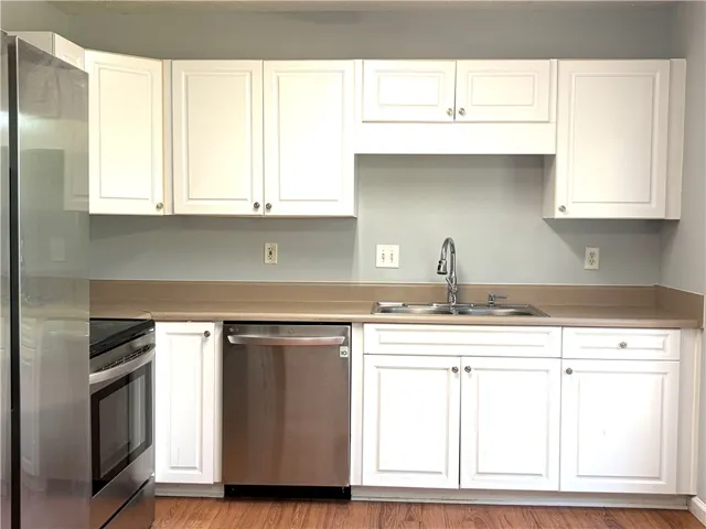 A streamlined kitchen showcasing bright cabinetry and essential stainless steel appliances.