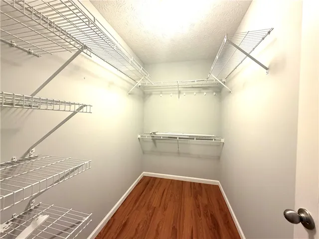 Ample closet space with wire shelving and wood-look flooring offers practical storage solutions.
