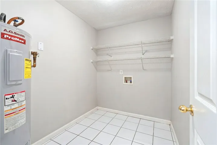 Functional utility space equipped with water heater and shelving for organized storage.