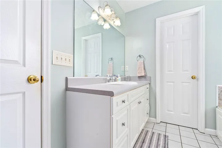 This clean bathroom features a spacious vanity and ample natural light, creating a refreshing atmosphere.