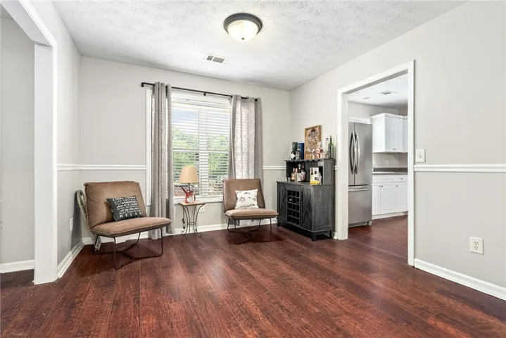 This versatile room features warm wood flooring and a large window, offering adaptable space for various living arrangements.