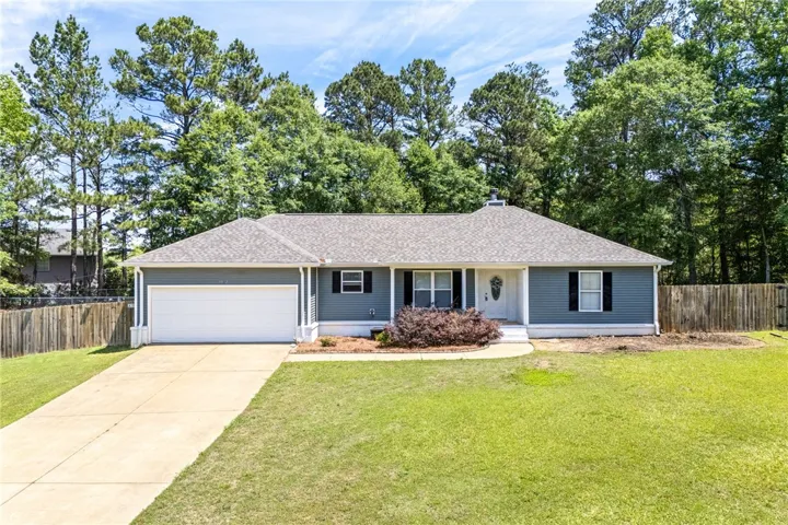 Charming single-story residence with attached garage and mature landscaping provides delightful curb appeal.