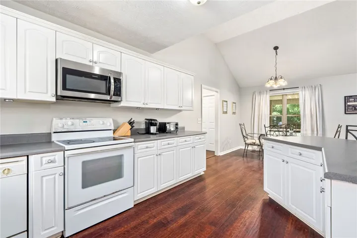 This spacious kitchen offers ample cabinetry and counter space, complemented by a convenient dining area for casual meals.