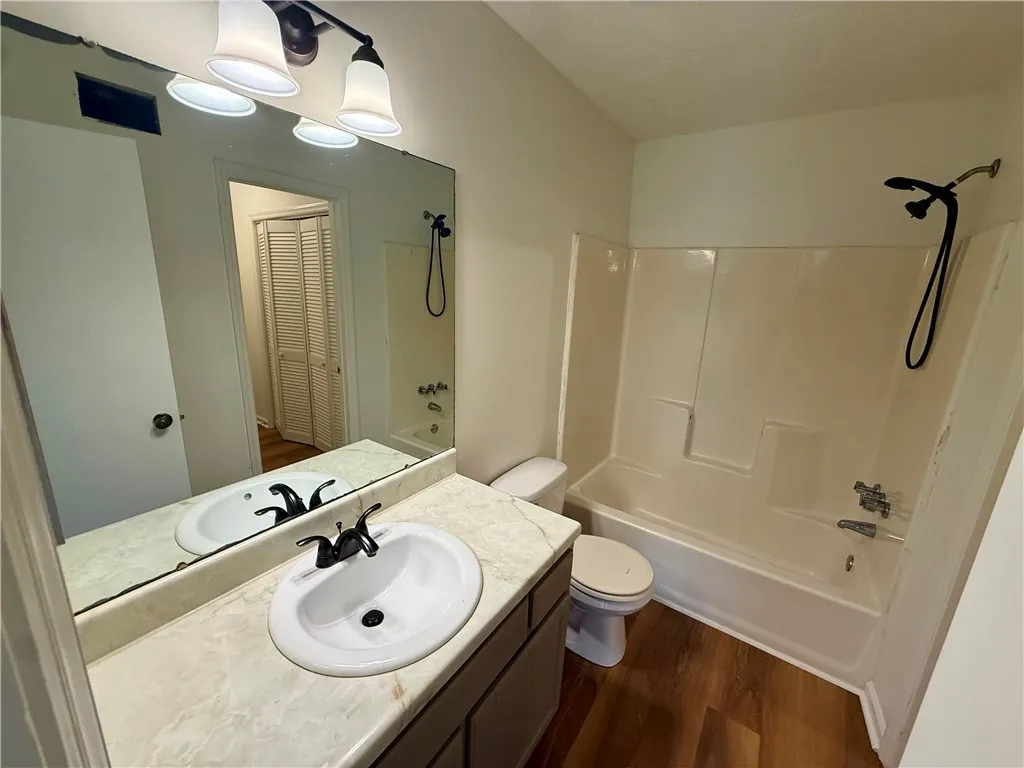 A well-maintained bathroom with a spacious vanity and combination tub-shower unit.