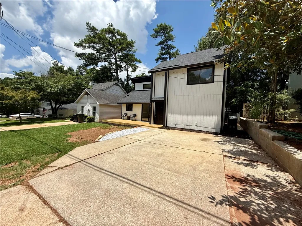 A striking modern facade with clean lines and mature trees, offering an inviting entry.