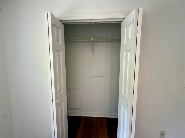 Functional closet with ample storage, featuring durable hardwood flooring and convenient wire shelving.