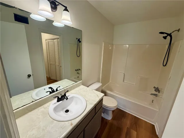 A well-maintained bathroom with a spacious vanity and combination tub-shower unit.