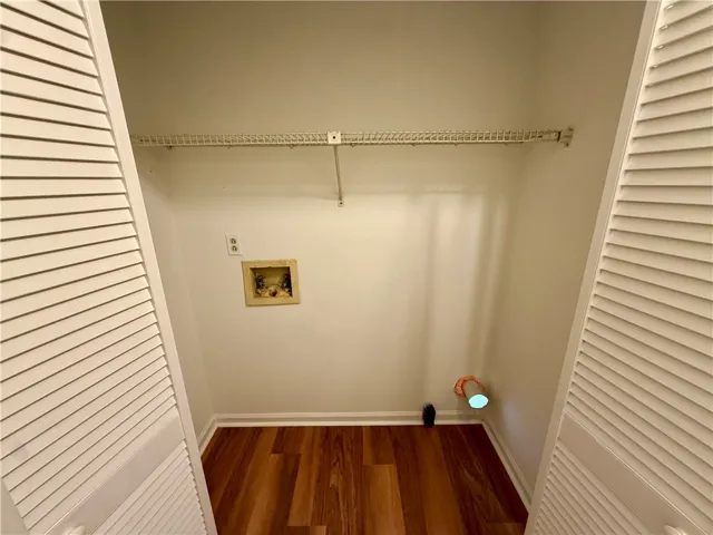 Functional laundry closet provides convenient hookups and storage solutions.