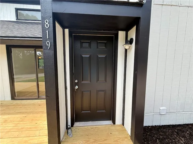A welcoming front entrance featuring a dark paneled door and modern outdoor lighting.