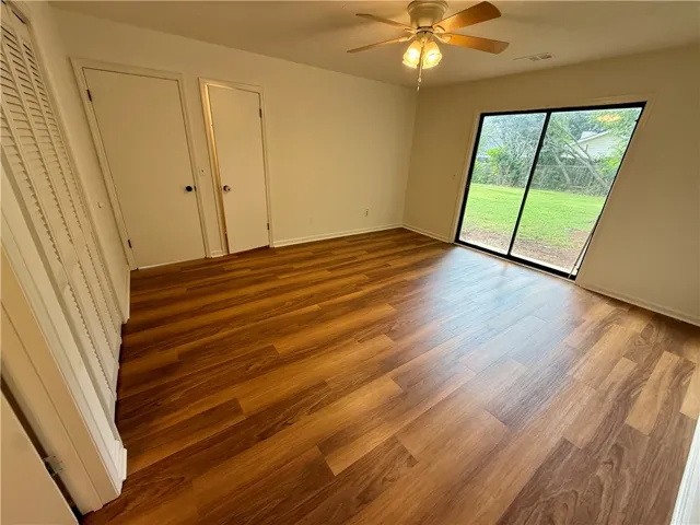 Laminate flooring and a sliding glass door enhance this well-lit room.