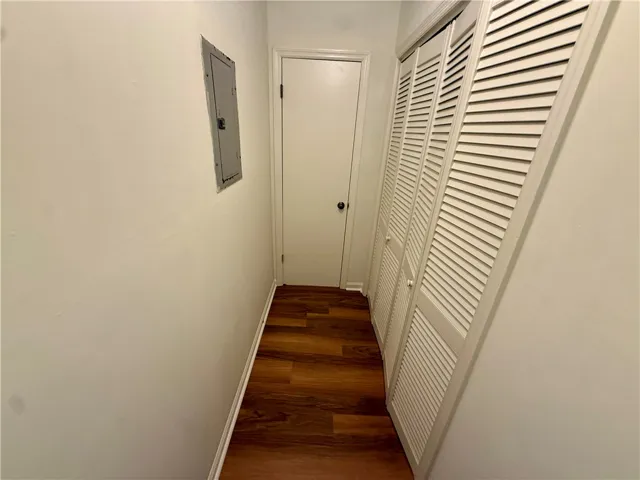 Hardwood flooring extends through this practical hallway, featuring louvered bi-fold doors.