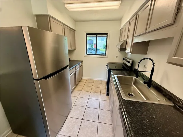A compact kitchen featuring stainless steel appliances and ample cabinetry.