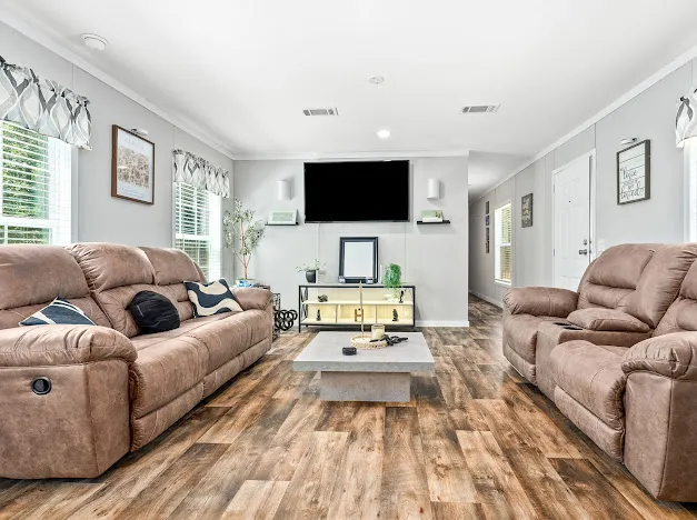 This relaxed living space features rich wood-look flooring and inviting, plush seating.