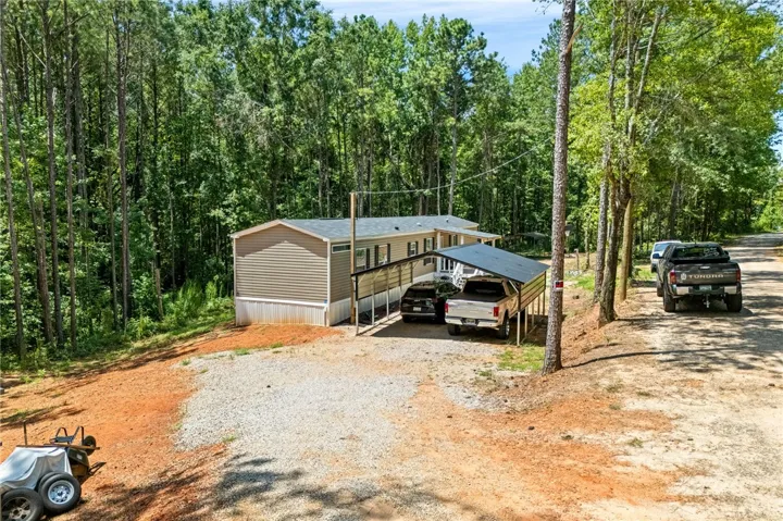 A tranquil, tree-lined lot provides a secluded setting for this property with ample parking.