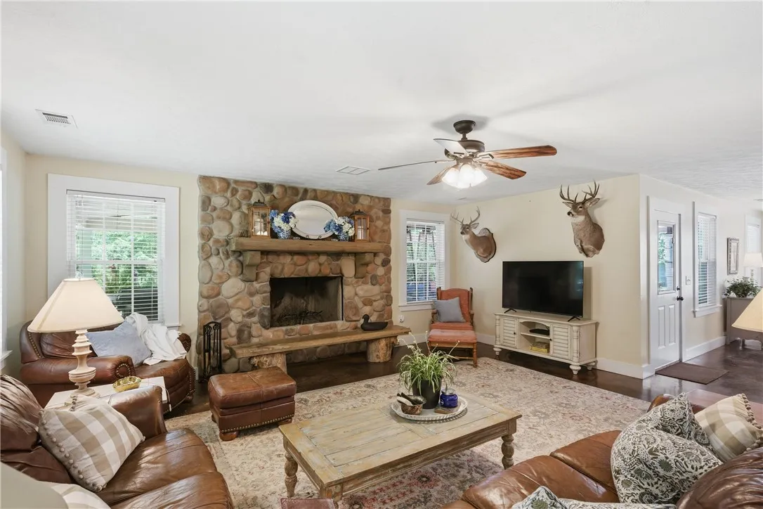 This living room offers a stone fireplace and rich wood flooring, perfect for relaxation.