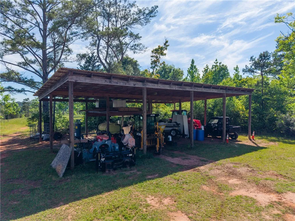 This spacious open-sided shed provides ample sheltered storage for various equipment and vehicles.