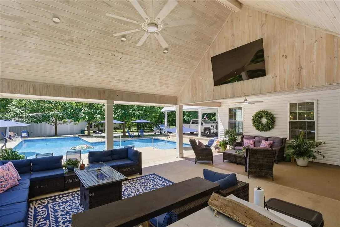 An inviting covered patio offers ample seating, a fire pit, and direct views of the sun-drenched private pool.