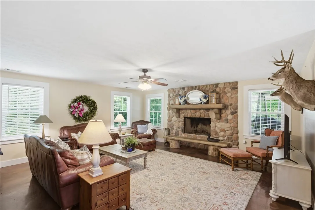 This inviting living space features a substantial stone fireplace and warm wood flooring.