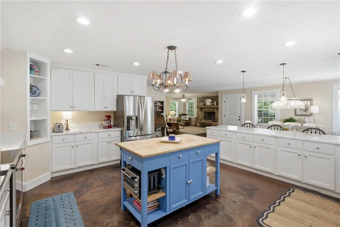 This kitchen presents a vibrant central island and ample counter space, ideal for culinary activities and casual dining.