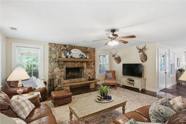 This living room offers a stone fireplace and rich wood flooring, perfect for relaxation.