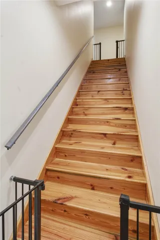 Natural wood treads and metal railings define this inviting stairwell leading to the upper level.