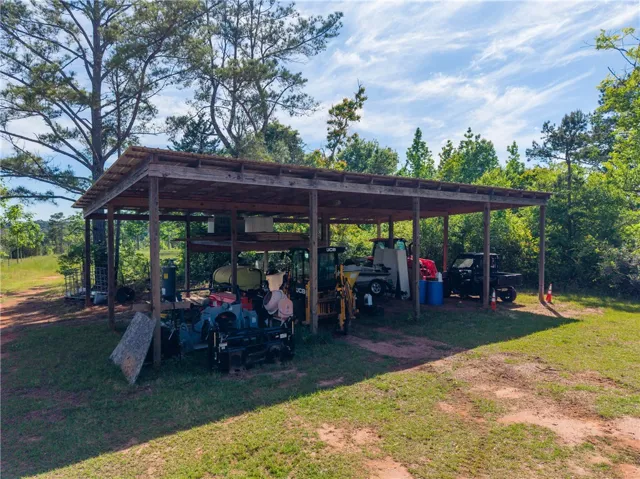 This spacious open-sided shed provides ample sheltered storage for various equipment and vehicles.
