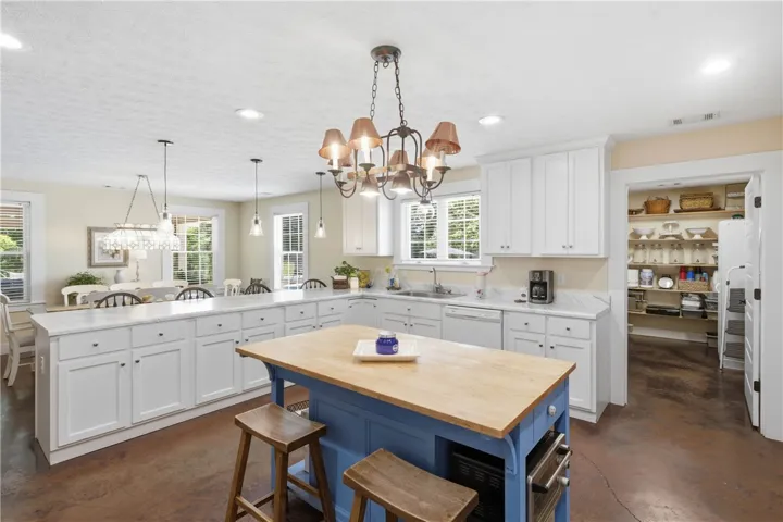 A well-appointed kitchen showcases white cabinetry, a spacious island, and an adjacent dining area.