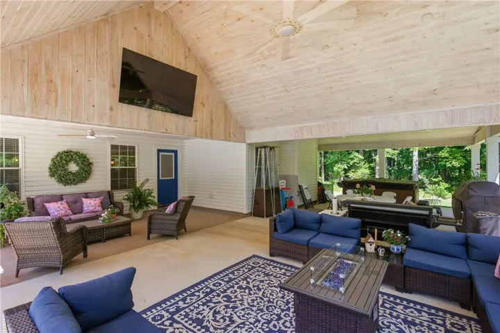 This spacious covered patio features ample seating and a vibrant outdoor area, perfect for entertaining.