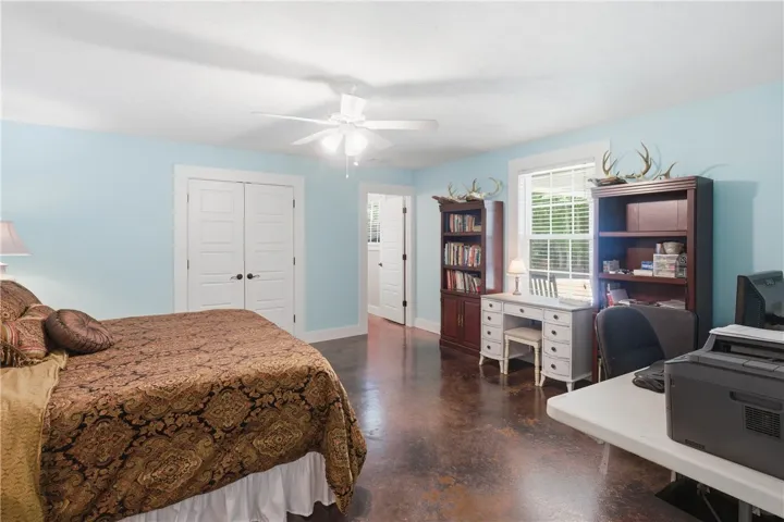 This spacious bedroom offers ample room for both rest and a functional home office setup.