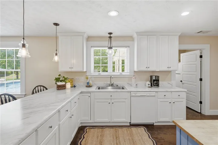 A well-appointed kitchen features ample counter space, bright cabinetry, and inviting pendant lighting.