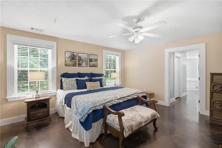 Relax and unwind in this serene bedroom, featuring warm-toned walls and gleaming polished concrete floors.