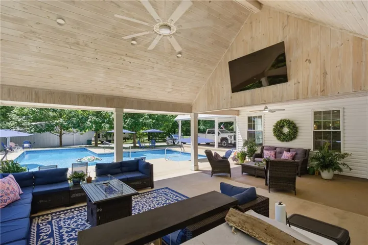 An inviting covered patio offers ample seating, a fire pit, and direct views of the sun-drenched private pool.