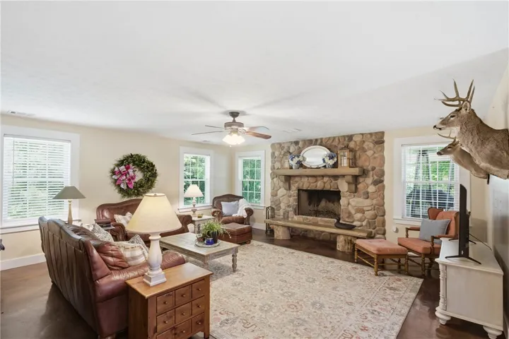 This inviting living space features a substantial stone fireplace and warm wood flooring.