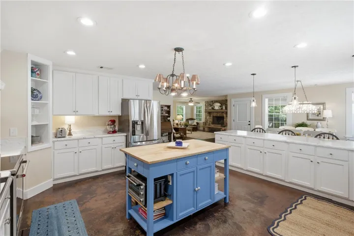 This kitchen presents a vibrant central island and ample counter space, ideal for culinary activities and casual dining.
