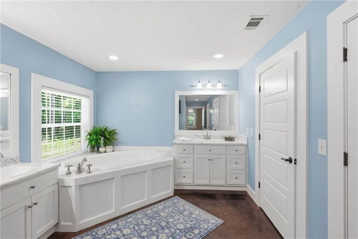Relax in this inviting primary bathroom, complete with a generous soaking tub and dual vanities.