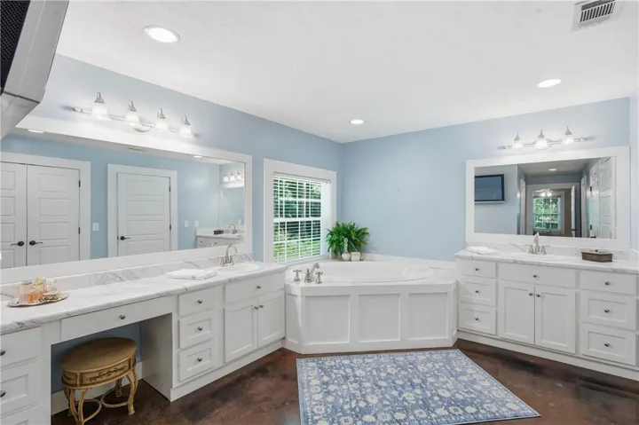 This primary bathroom features double vanities, a large soaking tub, and ample natural light for a serene retreat.