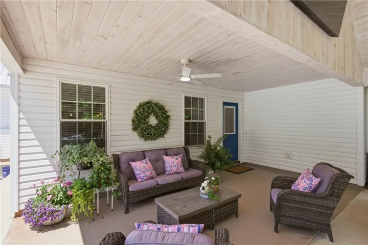 This inviting covered patio features a wood plank ceiling and offers a delightful outdoor relaxation space.