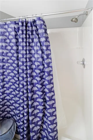 A refreshing shower fixture with a decorative curtain offers a clean and functional bathing space.