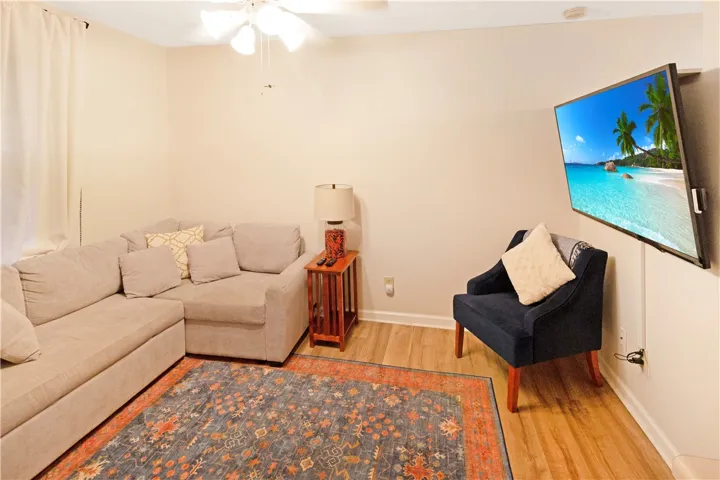 Blonde wood flooring and an inviting area rug anchor this comfortable living space.
