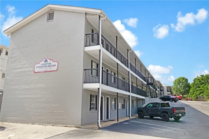 Multi-story condominium building with individual unit balconies and convenient on-site parking.